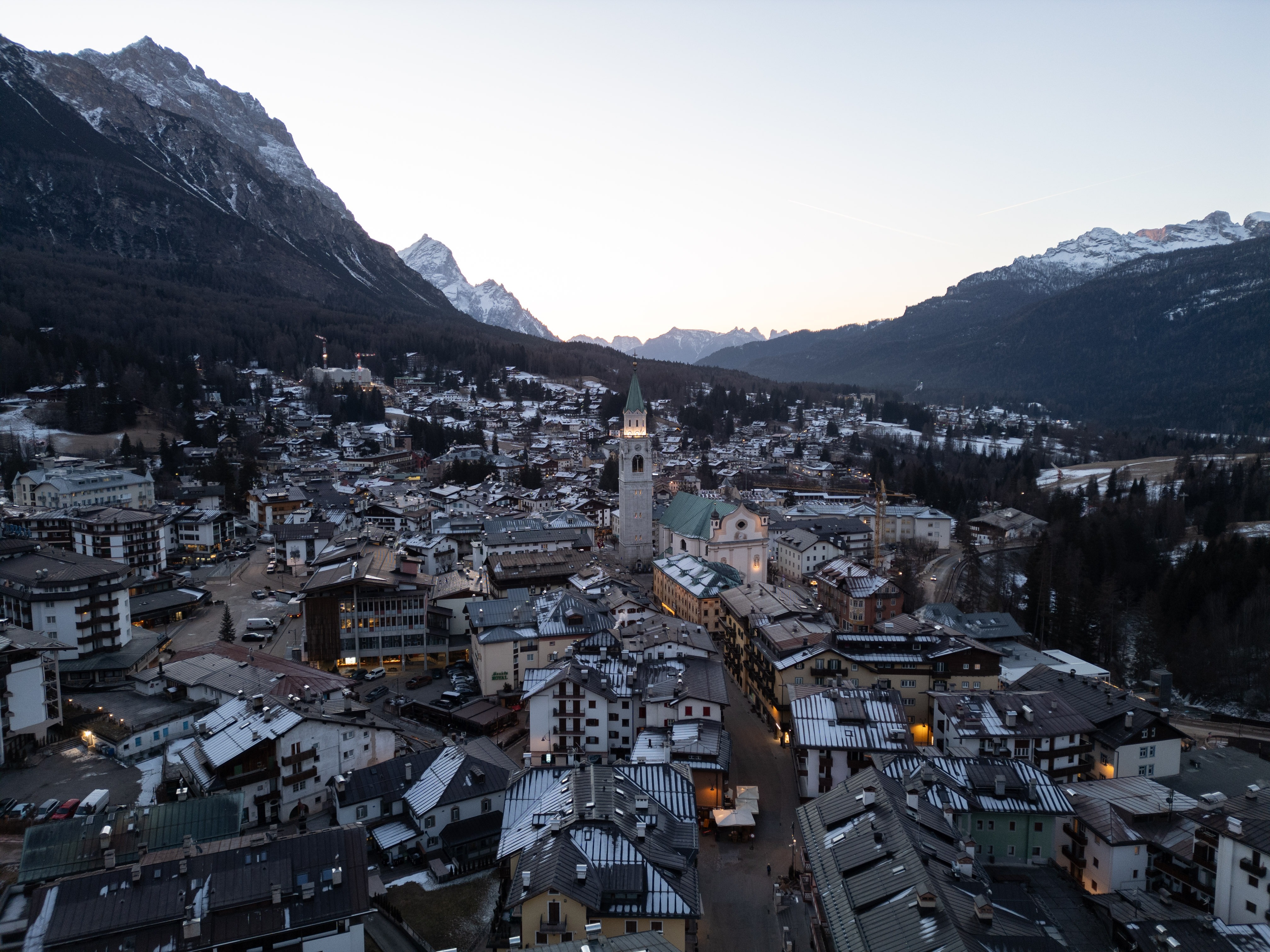The illuminated bell tower of the Basilica Minore dei Santi Filippo e Giacomo stands at the heart of Cortina d